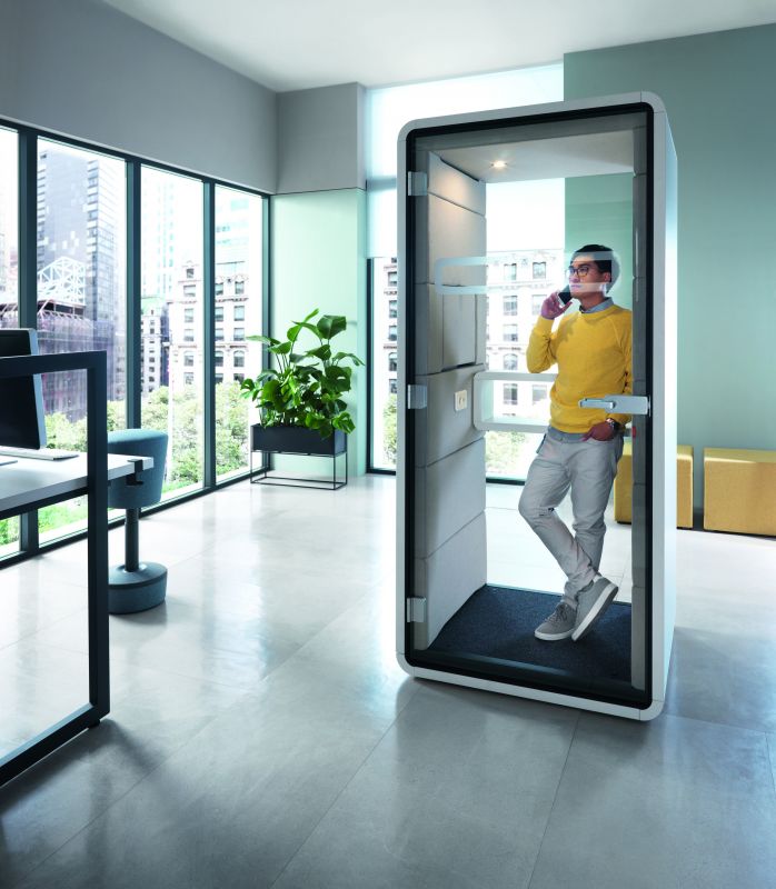 Mann telefoniert in einer HushPhone Meetingbox im Büro. Schallschutz für ungestörte Gespräche.